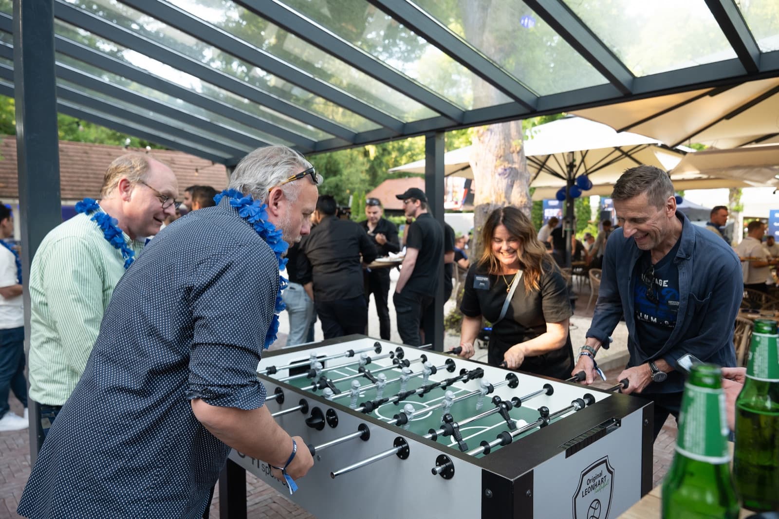 Gäste eines Sommerfests am Kickertisch